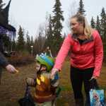 Photo by Megan Pacer/Peninsula Clarion Kenai resident Jill Schaefer guides her 3-year-old son, Cody, through a candy station on Sunday, Oct. 25, 2015 during the annual Spook Night Trick or Treat and Zombie 5K at the Tsalteshi Trails in Soldotna, Alaska.