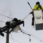 Ben Boettger/Peninsula Clarion Homer Electric Association workers use a fire extinguisher to put out a smoldering crossbeam on an electric pole in Soldotna on Tuesday, Nov. 3 near the intersection of the Kenai Spur highway and Marydale Avenue.