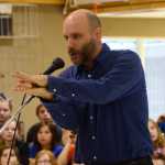 Photo by Megan Pacer/Peninsula Clarion Matt Boyle, a teacher at Nikiski North Star Elementary School and a veteran of the U.S. Coast Guard, tells stories from his time in the service to an audience on Wednesday, Nov. 11, 2015 at a Veterans Day assembly at the school in Nikiski, Alaska.