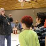 Photo by Megan Pacer/Peninsula Clarion Kris Barnes, a fifth-grade teacher at Nikiski North Star Elementary School, conducts her reading class in a musical renidtion of the Preamble of the Constitution on Wednesday, Nov. 11, 2015 at a Veterans Day assembly at the school in Nikiski, Alaska.