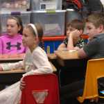 Photo by Megan Pacer/Peninsula Clarion From left to right: Zoya Fefelov, Lukia Chuprov, Lukah Kalugin, and Aquille Martushev listen to a presentation from Nouredine Mama, an exchange student from Cameroon, on Wednesday, Nov. 25, 2015 at Nikolaevsk School in Nikolaevsk, Alaska. Mama attends Homer High School and has been sharing his story at schools and churches in the area.
