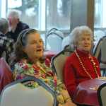 Photo by Megan Pacer/Peninsula Clarion Marilyn Bannock, left, and Doris Garrison, right, greet friends before digging into a Thanksgiving meal on Thursday, Nov. 26, 2015 at the Thanksgiving Potluck at the Kenai Senior Citizens Center in Kenai, Alaska.