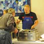 Photo by Elizabeth Earl/The Peninsula Clarion Doug Hayman, the principal of Tustumena Elementary, volunteers to serve Thanksgiving dinner at the Kasilof Community Church Thursday. The church partnered with Rocky's Cafe to serve a free dinner to the public.