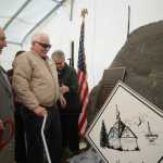Photo by Megan Pacer/Peninsula Clarion From left to right: former Kenai Mayor John Williams, Kenai Charter Commission member Richard Morgan and Kenai Mayor Pat Porter present a rock affixed with a memorial plaque on Sunday, Nov. 29, 2015 outside City Hall in Kenai, Alaska. The rock was dedicated to honor the commission members who signed Kenai's charter in 1963.