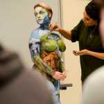 Photo by Rashah McChesney/Peninsula Clarion A king salmon swims over Sara Christensen's thigh during a live body painting presentation at Kenai Peninsula College - Kenai River Campus on Tuesday Dec. 1, 2015 in Soldotna, Alaska.