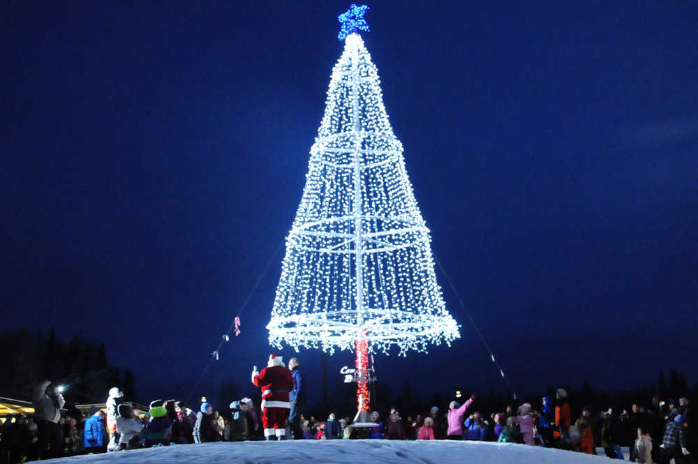 Ben Boettger/Peninsula Clarion Senator Peter Micciche and David Caswell (as Santa Claus) turned on an array of lights decked in a tree shape around a flagpole on Saturday, Dec. 5 in Soldotna Creek Park.