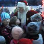 Ben Boettger/Peninsula Clarion Children cluster around Dave Caswell (center, in red) after the Soldotna Christmas tree lighting on Saturday, Dec. 5 in Soldotna Creek Park.