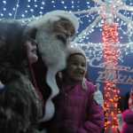 Ben Boettger/Peninsula Clarion Children pose with David Caswell (as Santa Claus) under the Conoco Philips-sponsored Soldotna christmas tree lights on Saturday, Dec. 5 in Soldotna Creek Park.