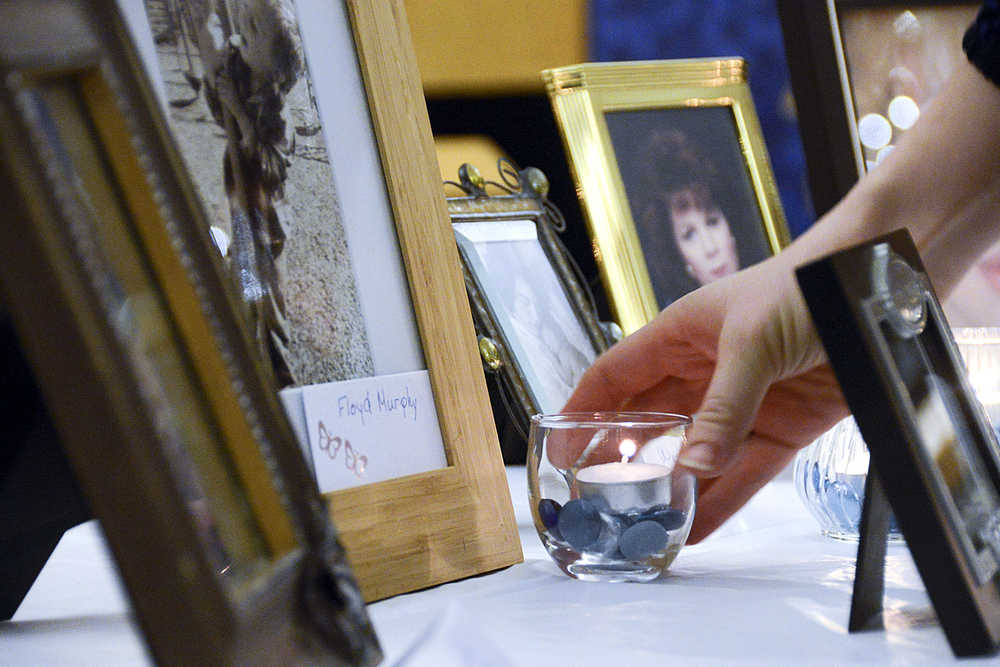 Photo by Megan Pacer/Peninsula Clarion Parents place lit candles in front of pictures of their dead children during the second annual Candlelight Remembrance Program on Sunday, Dec. 13, 2015 in Soldotna, Alaska. The local chapter of The Compassionate Friends host the vigil for parents dealing with the death of their children.