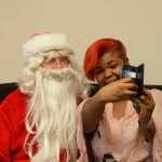 Photo by Megan Pacer/Peninsula Clarion Kenai Alternative High School senior Linda Byrd takes a picture with Hal Smalley, posing as Santa Clause, during the annual Grinch Day celebration on Thursday, Dec. 17, 2015 at the school in Kenai, Alaska. Byrd also celebrated her 19th birthday during the annual lunch and gift-giving event.