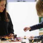 Photo by Kelly Sullivan/ Peninsula Clarion Seventh grader Brady Evoy shows eleventh grader Ceyara Showalter a few things about small drones, Wednesday, Dec. 9, 2015, at Nikiski Middle-High School in Nikiski, Alaska. Showalter recently joined the program and is still getting caught up, she said.