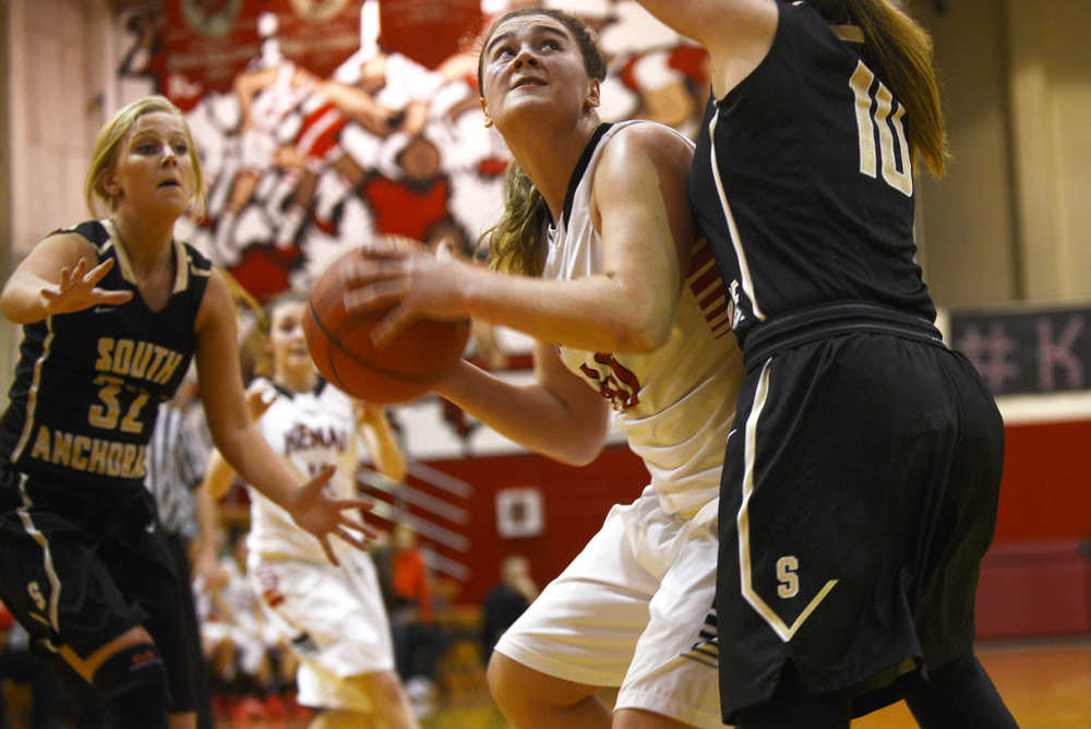 Ben Boettger/Peninsula Clarion Kenai basketball player Abby Beck eyes the basket through the arms of South Anchorage's Isabelle Lada (right), as Marina Olson closes behind her during a game on Friday, Dec. 18 at Kenai Central High School.