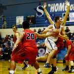 Ben Boettger/Peninsula Clarion Soldona basketball player Derek Evans glides between Houston's Ben Pelasa (left) and Tony Dika during a game on Friday, Dec. 18 at Soldotna High School.