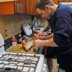 Photo by Elizabeth Earl/Peninsula Clarion Firefighter Nate Nelson prepares the turkey for the joint Central Emergency Services Christmas dinner Friday afternoon. The volunteers and staff from the various stations and their families come to the Soldotna station and share in a holiday meal.
