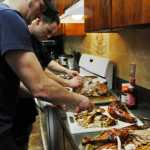 Photo by Elizabeth Earl/Peninsula Clarion Firefighters Matt Seizy (front) and Nate Nelson (back) took on the task of dividing up the turkeys for the joint Central Emergency Services dinner Christmas Day.