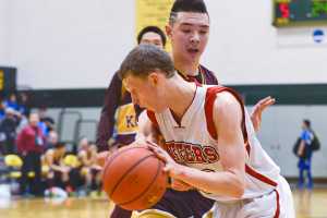Photo by Rashah McChesney/Peninsula Clarion  Seldovia's Aidan Philpot works his way around Kotlik's Juwan Akaran during their game at the 2015 March Madness Small Schools championships on Saturday March 14, 2015 in Anchorage, Alaska.