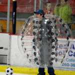 Photo by Rashah McChesney/Peninsula Clarion As a group of kids looks on, a man looks for an opening to pass a soccer ball during a game of "bubble soccer," on Dec. 4, 2015 at the Soldotna Sports Complex in Soldotna, Alaska. The City Council will review a pricing schedule from the city's Parks and Recreation Department in January, then the game should be available to rent at the center.