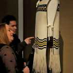 Photo by Elizabeth Earl/Peninsula Clarion Summer Parker (front) and Skye Lew (back) admire one of the tunics woven in the Ravenstail style, a type of weaving indigenous to the Pacific coast of Canada and Alaska. A display of multiple pieces woven by Juneau artist Kay Field Parker will be on display at the Kenai Visitors and Cultural Center for the winter and spring.