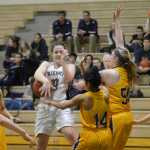 Photo by Jeff Helminiak/Peninsula Clarion Nikiski's Hallie Riddall tries to get a shot off against the defense of Kodiak's Nelly Hernandez (14) and Kathryn Carstens (50) on Thursday at Nikiski High School.