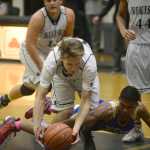 Photo by Joey Klecka/Peninsula Clarion Nikiski senior guard Cade Anderson (center) scrambles after the ball over Bethel sophomore Clevon Constantine, Saturday at the Nikiski Tip-Off Tournament. Nikiski defeated Bethel 64-54 to win the championship.