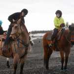 Photo by Megan Pacer/Peninsula Clarion Soldotna resident Madelyn Barkman, left, and Kenai resident Mercedes Tapley, right, ride along the beach with other members of the Alaska C & C Horse Adventures group on Monday, Jan. 18, 2016 in Kenai, Alaska.