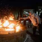 Photo by Megan Pacer/Peninsula Clarion Soldotna resident Abraham Anasogak throws a plant offering into the flames of a Raven Fire Circle during a healing gathering called "You and Me" on Wednesday, Jan. 20, 2016 at the Dena'ina Wellness Center in Kenai, Alaska. The gatherings are held periodically to support those affected by suicide or death, and have lavender, sage and sweetgrass available for participants to burn in the healing process.