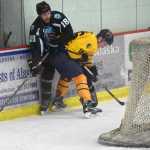 Photo by Jeff Helminiak/Peninsula Clarion Brown Bears forward Collin Appleton looks to make a play from behind the Jr. Blues net while Jr. Blues forward Matt Long keeps him pinned to the boards Friday, Jan. 22, 2016, at the Soldotna Regional Sports Complex.