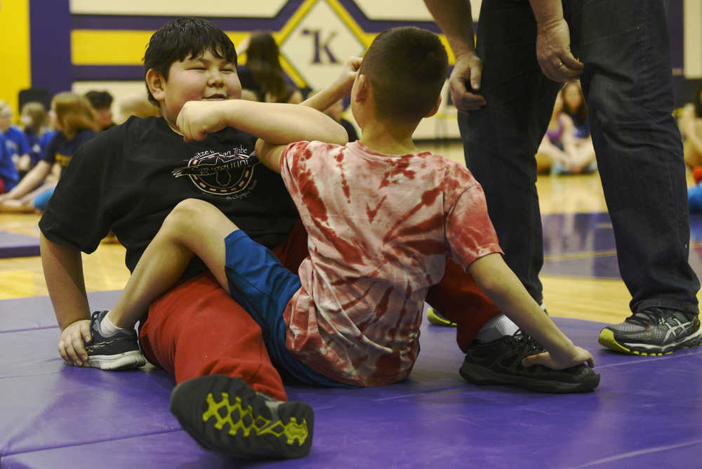 Ben Boettger/Peninsula Clarion Samiel Wilson (left) prepares to go against Seth Strange in the arm pull event of the Native Youth Olympics Winter Games Invitational on Saturday, Jan. 23 at Kenai Middle School.