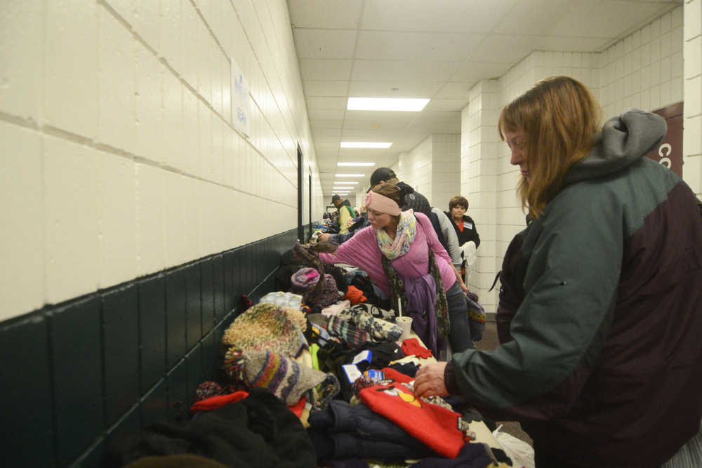 Photo by Megan Pacer/Peninsula Clarion Monieque Essig, of the Soldotna area, picks up hats, gloves, boots and more during Project Homeless Connect on Thursday, Jan. 28, 2016 at the Soldotna Regional Sports Complex in Soldotna, Alaska.