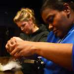 Photo by Megan Pacer/Peninsula Clarion LaDonna McCray, right, and Amber Mullican, left, work on their respective flies during a workshop hosted by the Trout Unliminted Kenai Peninsula Chapter and Soldotna's Sportsman's Warehouse on Tuesday, Feb. 3, 2016 at the Main Street Tap and Grill in Kenai, Alaska.