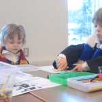 Photo by Megan Pacer/Peninsula Clarion Temperance Taylor, 3, and her 5-year-old brother, Westley Taylor, color in drawings in their handmade robes and scarves during Harry Potter Book Night on Thursday, Feb. 4, 2016 at the Soldotna Public Library in Soldotna, Alaska.