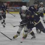 Photo by Joey Klecka/Peninsula Clarion Soldotna junior Matthew Daugherty (left) competes for the puck against Homer freshman Tucker Weston (right) Thursday at the North Star Conference tournament at the Soldotna Regionals Sports Complex.