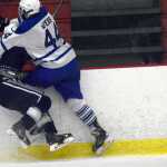 Photo by Jeff Helminiak/Peninsula Clarion Palmer's Bowen Webb checks Soldotna's Jace Urban into the boards Friday at the North Star Conference hockey tournament at the Soldotna Regional Sports Complex.
