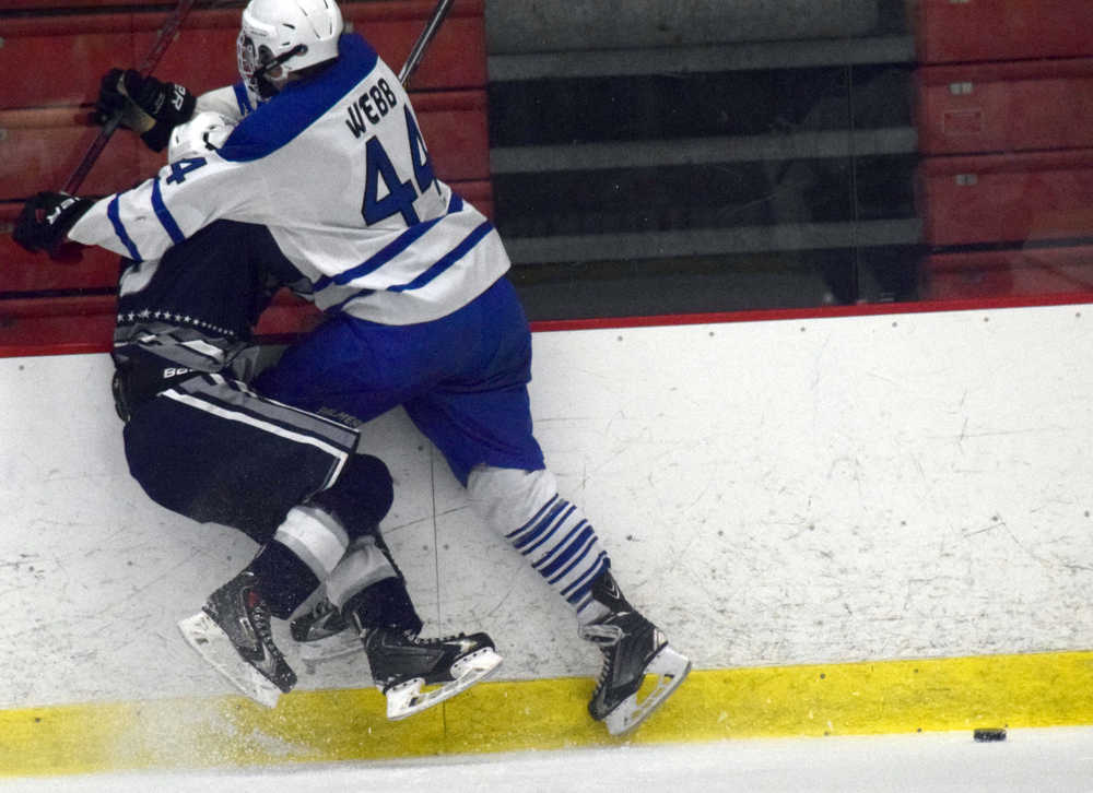 Photo by Jeff Helminiak/Peninsula Clarion Palmer's Bowen Webb checks Soldotna's Jace Urban into the boards Friday at the North Star Conference hockey tournament at the Soldotna Regional Sports Complex.