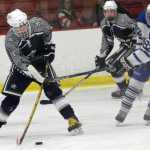 Photo by Jeff Helminiak/Peninsula Clarion Soldotna's Matthew Daugherty fires a shot on goal as Palmer's Valary Dietz defends Friday at the North Star Conference hockey tournament at the Soldotna Regional Sports Complex.