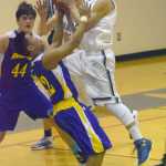Photo by Jeff Helminiak/Peninsula Clarion Soldotna's Timmy Smithwick drives on Kodiak's Bryan Mangrobang on Friday, Feb. 12, 2016, at Soldotna High School.