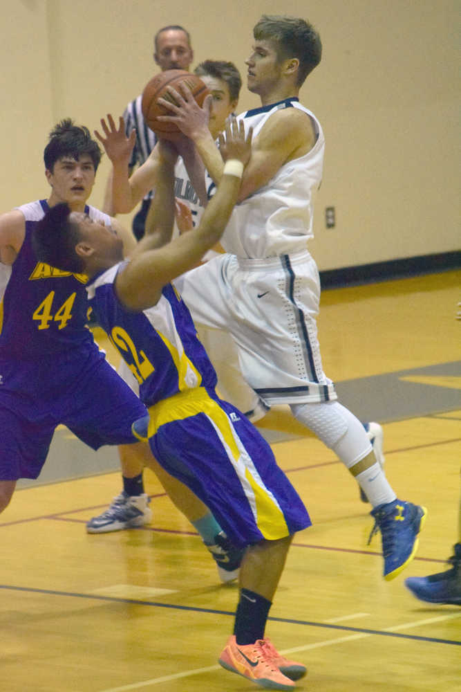 Photo by Jeff Helminiak/Peninsula Clarion Soldotna's Timmy Smithwick drives on Kodiak's Bryan Mangrobang on Friday, Feb. 12, 2016, at Soldotna High School.