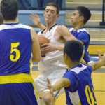 Photo by Jeff Helminiak/Peninsula Clarion Soldotna's Derek Evans drives to the hoop on Kodiak's Ryan Bezona (5), Augie Cauging and Billy Accaide on Friday at Soldotna High School.