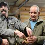 Members of the Kenai Peninsula Woodturners Chapter discuss the construction of a wooden bowl and lid during a meeting on Saturday, Feb. 13 near Soldotna.