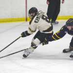 Photo by Jeff Helminiak/Peninsula Clarion Kenai River Brown Bears forward Nick Klishko drives the net on Springfield Jr. Blues defenseman Kyle Meeh on Friday at the Soldotna Regional Sports Complex.