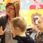 Photo by Kelly Sullivan/ Peninsula Clarion Principal Margaret Gilman walks Sam Yerkes and Bryce Dederick through how to make the morning announcements Wednesday, Feb. 24, 2016, at Nikiski North Start Elementary in Nikiski, Alaska. She said it is a very brief "20-second" training period.