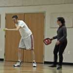 Photo by Elizabeth Earl/Peninsula Clarion Tony Kaser (left) gets coaching from Juanita Owens (right) before serving in a game of pickleball at the Sterling Community Center Feb. 18.