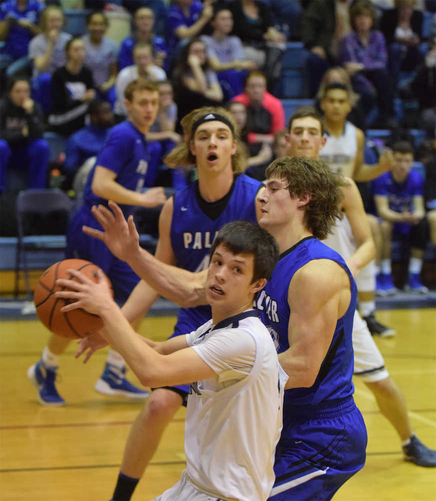 Photo by Joey Klecka/Peninsula Clarion Soldotna senior Dylan Kuntz looks for a teammate to pass to while Palmer forward Chase Ferris and Michael Kluting look on.