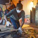 Spraypaint artist Gemma Amorelli sprays in the black outline of a one-color stencil of a friend's face on Monday, Feb. 22 near Soldotna. "I like people with a lot of wrinkles and character in their face," Amorelli said. "I picked this one because it's a picture of somebody I know with his face kind of crinkled up in the middle, like he's smelling something gross."   Amorelli