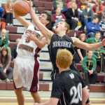 Photo by Joey Klecka/Peninsula Clarion Nikiski senior Nathan Carstens (center) attempts to swat away a rebound from Grace guard Nate Salima (left) in Friday's semifinal contest at the Southcentral Conference tournament at Grace Christian High.