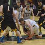 Photo by Joey Klecka/Peninsula Clarion Ninilchik senior Pat Brandt (center) fights for a loose ball Thursday against King Cove at the Class 1A March Madness state tournament at the Alaska Airlines Arena in Anchorage.