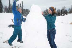 Dmitry Marlowe, 9, and Lydia Marlowe, 14, put the finishing touches on a snowman on Sunday, March 20, 2016 at the Kenai Golf Course in Kenai, Alaska. The first day of Spring found Kenai coated in a layer of wet, sticky snow after several days of sunshine.