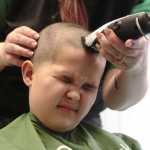 Brian Bliss finishes getting a shave from barber Crystal Stonecipher of the Hey Good Lookin' Salon at a St. Baldrick's head-shaving fundraiser at Kenai Peninsula College on Thursday, March 24. Over 17 people had their heads shaved in exchange for donations to St. Baldrick's Foundation, a research charity for pediatric cancer.