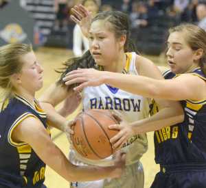 Photo by Joey Klecka/Peninsula Clarion Homer sophomore Alissa Cole and senior Aurora Waclawski trap Barrow's Kuutuuq Danner in Saturday's Class 3A state championship final at the Alaska Airlines Center in Anchorage.