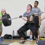 Photo by Jeff Helminiak/Peninsula Clarion Sophomore Rykker Riddall sets the record in the Freshmen/Sophomore Clean on Wednesday in the Speed and Strength Training competition. At left, yelling encouragement, is Riddall's father, Ted Riddall.